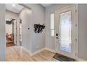 Bright and spacious foyer with light wood floors, hat rack, and an elegant front door with glass at 129 Major Bowling Pl, Henderson, NV 89011
