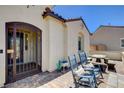 Inviting front porch with an iron gate, two rocking chairs and a table, and a brick paved patio at 129 Major Bowling Pl, Henderson, NV 89011