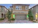 Charming two-story home featuring a neutral stucco facade, manicured landscaping, and a two-car garage at 2787 Donatello Manor Pl, Henderson, NV 89044