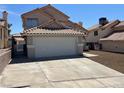 Two-story home featuring a two-car garage, landscaped front yard, and tile roof at 3238 Canyon Terrace Dr, Laughlin, NV 89029