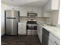 Updated kitchen with stainless steel appliances, white cabinets, and marbled countertops at 3930 University Center Dr # 901, Las Vegas, NV 89119