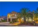 Elegant two-story home with three-car garage, stone accents, arched entry and lush palm trees at 4045 Abernethy Forest Pl, Las Vegas, NV 89141
