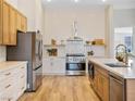 Bright kitchen with white tile backsplash, stainless steel appliances, and wood-look tile flooring at 4314 Livorno Ave, Las Vegas, NV 89141