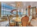 Elegant dining area with spiral staircase, chandelier, and city view through expansive windows at 4525 Dean Martin Dr # 2503, Las Vegas, NV 89103