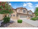 Charming two-story home with a two-car garage, desert landscaping, and beautiful trees in the front yard at 5653 Mount Athos St, North Las Vegas, NV 89031