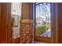 Inviting entryway featuring a decorative iron gate and stone accents, welcoming guests into this beautiful home at 72 Broken Putter Way, Las Vegas, NV 89148