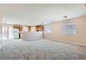 Spacious living room with new carpet flooring and an open layout towards the kitchen area at 7547 Rolling River Dr, Las Vegas, NV 89131