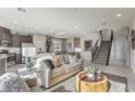 Bright, open-concept living area with modern furnishings, stainless steel appliances, and stylish staircase at 8442 Sycamore Creek St, Las Vegas, NV 89113