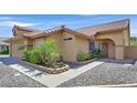 Inviting home exterior with a well-kept lawn, mature landscaping, and a cozy entrance way with an arched porch at 100 Crossfoot Terrace Ct, Henderson, NV 89002