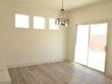 Bright dining room with three windows, sliding glass doors, and wood-look floors at 1025 Appaloosa Hills Ave, North Las Vegas, NV 89081