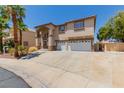 Two-story home featuring stucco siding, desert landscaping, an arched entryway, and a three-car garage at 1054 Broomfield Dr, Henderson, NV 89074