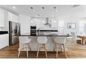 Modern kitchen boasts stainless steel appliances, white cabinetry, granite countertops and a center island at 10863 Gardenova Ave, Las Vegas, NV 89166