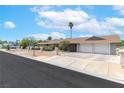 Street view of home with two car garage, desert landscaping, and mature palm tree at 120 W Highland Dr, Henderson, NV 89015