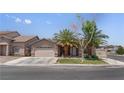 Single-Gathering home boasting desert landscaping, attached garage, and cozy front porch seating at 1310 Ripplestone Ave, North Las Vegas, NV 89081