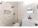 Well-lit bathroom featuring marble tile, a modern vanity, and a stylish shower at 1313 Purple Sage Ave, Las Vegas, NV 89108