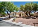 Inviting single-story home with desert landscaping, concrete steps, and mature shade trees at 1830 Lake Wales St, Henderson, NV 89052