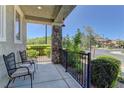 Cozy front porch featuring stone pillar, rod iron railing, and comfortable seating, providing a relaxing outdoor space at 1904 Via Firenze, Henderson, NV 89044