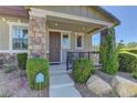 Inviting front porch with stone supports and a cozy seating area, perfect for relaxing outdoors at 1904 Via Firenze, Henderson, NV 89044