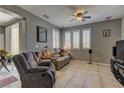 Comfortable living room with neutral tones, tile flooring, shutters and a ceiling fan at 1904 Via Firenze, Henderson, NV 89044