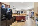 Kitchen with dark cabinets, light countertops, black appliances, and tile flooring at 2716 Orchid Moon Ct, North Las Vegas, NV 89031