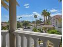 Balcony view overlooking a tranquil street lined with mature palm trees and stunning architecture at 3372 Westwind Rd, Las Vegas, NV 89146