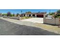 Single-story home with white and brick exterior, well-kept landscaping and a large driveway at 3917 Leon Ave, Las Vegas, NV 89130