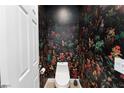 A bathroom with colorful wallpaper, toilet and a white door at 3934 Sangre De Cristo Ave, Las Vegas, NV 89118