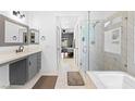 Modern bathroom with marble tiled walk-in shower, soaking tub, dual sink vanity, and contemporary finishes at 4212 Helens Pouroff Ave, North Las Vegas, NV 89085