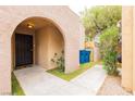 Inviting front entrance with an arched entryway, security gate, and well-maintained landscaping at 4232 Park Ct, Las Vegas, NV 89110