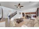 Open living room with tile floors, ceiling fan, staircase, and neutral decor at 4641 Therapeutic St, North Las Vegas, NV 89031