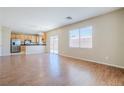 Open-concept living room and kitchen area with wood floors and stainless steel appliances at 5282 Monterey Park Cir, Las Vegas, NV 89146
