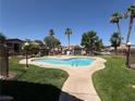 Inviting community pool with clear blue water, surrounded by lush landscaping and palm trees at 5751 E Hacienda Ave # 226, Las Vegas, NV 89122