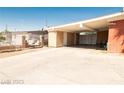 Large open carport with attached storage, a spacious driveway, and a secure metal fence at 624 N Bruce St, Las Vegas, NV 89101