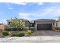 Charming single-story home featuring desert landscaping, a paver driveway and walkway, and a two car garage at 6421 Winecup St, Las Vegas, NV 89149