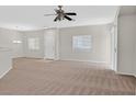 Spacious living room with carpet flooring, neutral paint, bright windows, and a ceiling fan at 6559 Tumbleweed Ridge Ln # 103, Henderson, NV 89011
