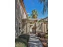 Beautiful walkway leading to the home's entrance with lush landscaping and a covered patio at 7716 Bauble Ave, Las Vegas, NV 89128