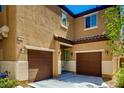 Inviting two-story home featuring a two-car garage, complemented by warm stucco and a covered entrance at 7760 Trends Ct, Las Vegas, NV 89149