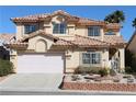 Two-story home showcasing a well-manicured yard, two-car garage, and a distinctive tile roof at 8982 Emerald Waters Ct, Las Vegas, NV 89147