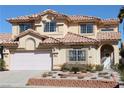 Two-story home showcasing a well-manicured yard, two-car garage, and a distinctive tile roof at 8982 Emerald Waters Ct, Las Vegas, NV 89147