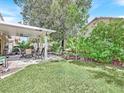 Lush backyard featuring a covered patio, green lawn, and mature landscaping, perfect for outdoor living at 9517 Mountainair Ave, Las Vegas, NV 89134