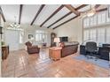 Warm living room with exposed wood beams, terracotta tile flooring, and plantation shutters at 9517 Mountainair Ave, Las Vegas, NV 89134
