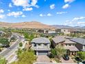An aerial view of a home in a residential community with desert mountain views and blue skies at 7017 Pearl Hilltop Ct, Las Vegas, NV 89148