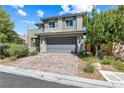 Charming two-story home featuring manicured landscaping, brick driveway, and a gray two-car garage at 7017 Pearl Hilltop Ct, Las Vegas, NV 89148