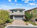 Charming two-story home featuring manicured landscaping, brick driveway, and a gray two-car garage at 7017 Pearl Hilltop Ct, Las Vegas, NV 89148
