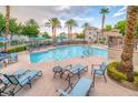 Community pool featuring lounge chairs, palm trees, and well-maintained landscaping at 10001 Peace Way # 2322, Las Vegas, NV 89147