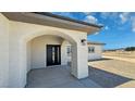 Inviting front entrance with a modern black door and arched entryway, enhancing curb appeal at 1131 Lupin St, Pahrump, NV 89048