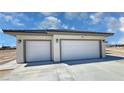 Spacious three-car garage with modern doors and exterior lighting fixtures at 1131 Lupin St, Pahrump, NV 89048