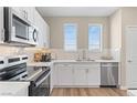 Well-lit kitchen with white cabinets, stainless steel appliances, and a modern backsplash at 137 Harmonica Ave # Lot 19, Henderson, NV 89015