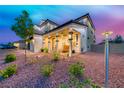 Landscaped front yard featuring a covered porch with a seating area, providing a welcoming entrance to the home at 1523 Great Sands St, Boulder City, NV 89005