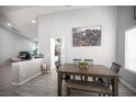 Bright dining area features a wooden table and chairs, complemented by a modern light fixture and decor at 1553 Bright View Dr, Las Vegas, NV 89119